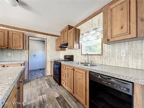 kitchen featuring hardwood / wood-style floors, black appliances, sink, and light stone countertops