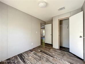 unfurnished bedroom featuring a closet and dark hardwood / wood-style flooring