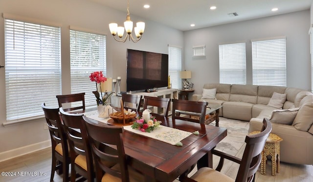 dining space with a chandelier and light hardwood / wood-style flooring