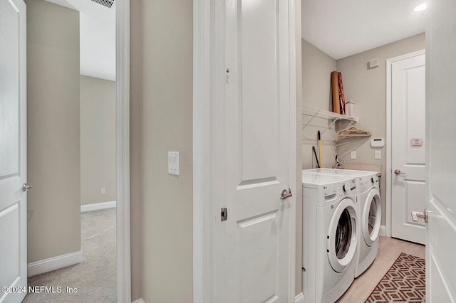 washroom featuring light hardwood / wood-style floors and separate washer and dryer