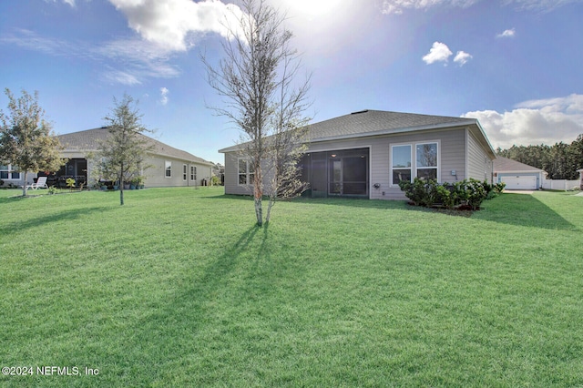 rear view of property featuring a lawn and a sunroom