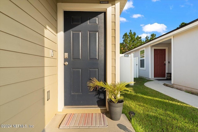 doorway to property featuring a lawn