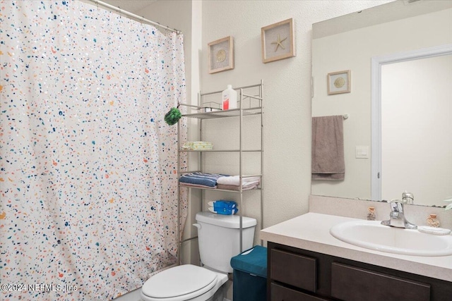 bathroom featuring toilet, walk in shower, and vanity