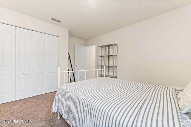 bedroom featuring a closet, a textured ceiling, and carpet