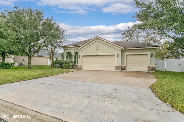 ranch-style house featuring a garage and a front lawn