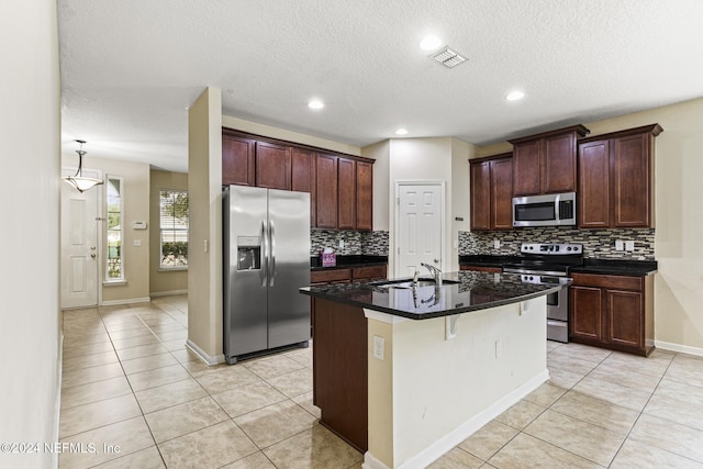 kitchen featuring stainless steel appliances, sink, a breakfast bar, a kitchen island with sink, and decorative backsplash