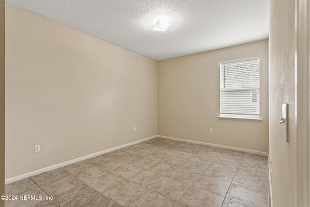 unfurnished room featuring a textured ceiling