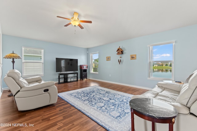 living room featuring a healthy amount of sunlight, dark wood-type flooring, and ceiling fan