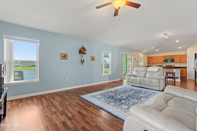 living room with ceiling fan, lofted ceiling, and dark hardwood / wood-style flooring