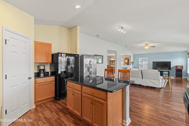 kitchen with a center island, black fridge, stainless steel fridge, vaulted ceiling, and dark wood-type flooring