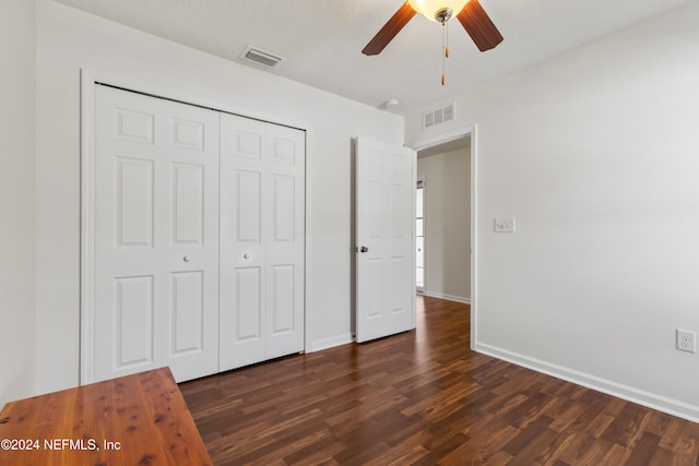 unfurnished bedroom featuring a closet, a textured ceiling, ceiling fan, and dark hardwood / wood-style flooring