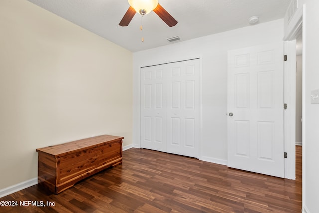 bedroom with a closet, dark hardwood / wood-style floors, a textured ceiling, and ceiling fan