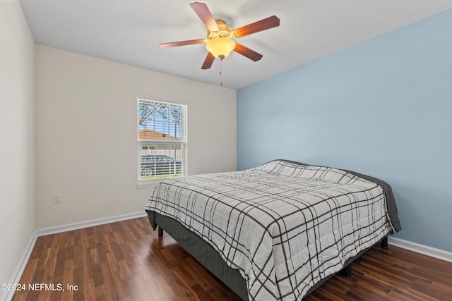 bedroom with ceiling fan, a textured ceiling, and dark hardwood / wood-style floors