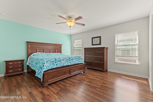 bedroom featuring dark wood-type flooring, ceiling fan, and multiple windows