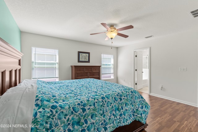 bedroom featuring hardwood / wood-style floors, a textured ceiling, connected bathroom, and ceiling fan