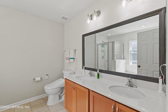 bathroom featuring toilet, an enclosed shower, vanity, and tile patterned floors