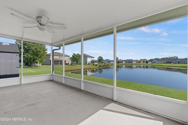 unfurnished sunroom with a water view and ceiling fan