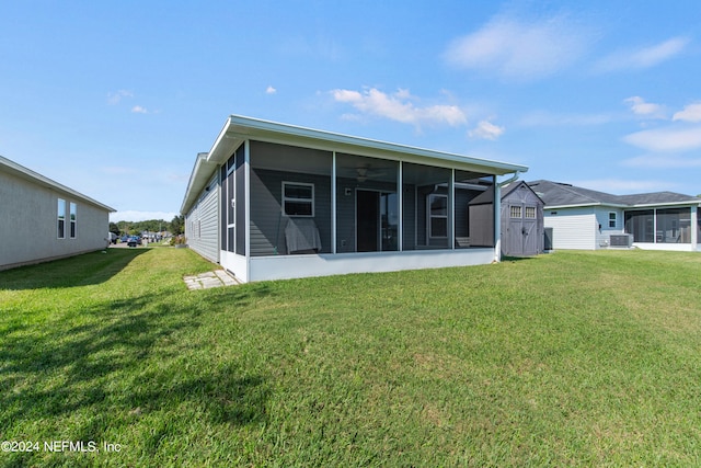 rear view of house with a sunroom, central AC, and a lawn