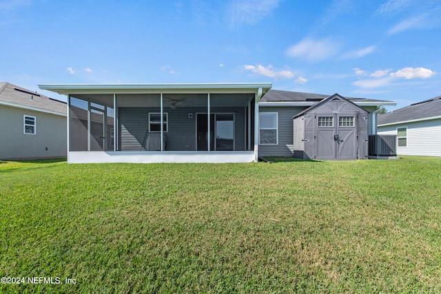 back of property with a yard, a sunroom, a shed, and ceiling fan