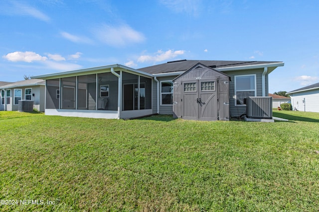 back of property with central air condition unit, a shed, a lawn, and a sunroom