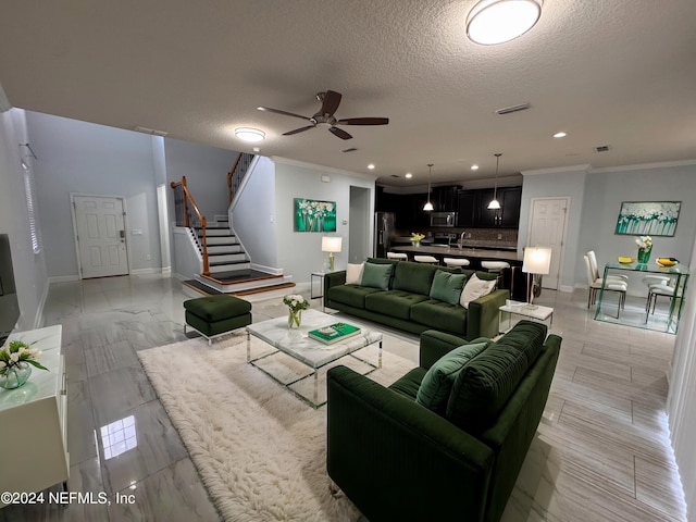 living room with ceiling fan, a textured ceiling, crown molding, and sink