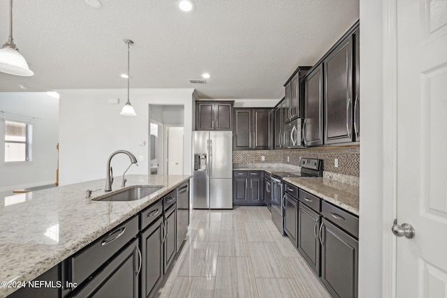 kitchen with light stone counters, sink, appliances with stainless steel finishes, dark brown cabinets, and decorative light fixtures