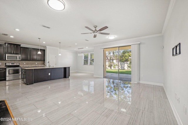 kitchen featuring a kitchen island with sink, backsplash, a breakfast bar area, stainless steel appliances, and hanging light fixtures