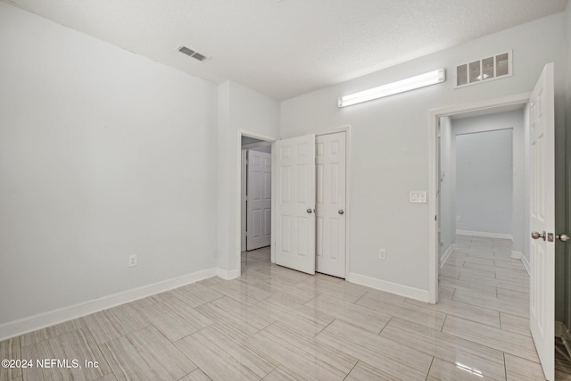 unfurnished bedroom featuring a closet and a textured ceiling