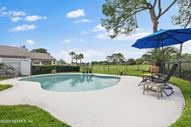 view of pool featuring a patio and a yard