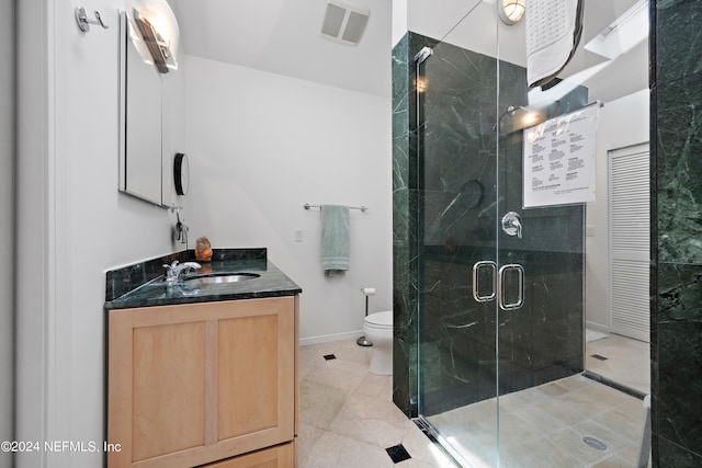 bathroom with tile patterned floors, vanity, walk in shower, and toilet