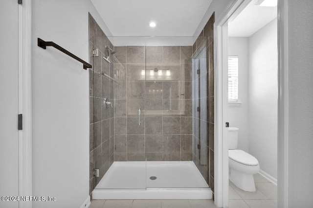 bathroom featuring tile patterned flooring, a shower with door, and toilet