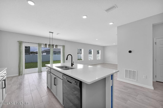 kitchen with an island with sink, sink, light hardwood / wood-style floors, hanging light fixtures, and black dishwasher