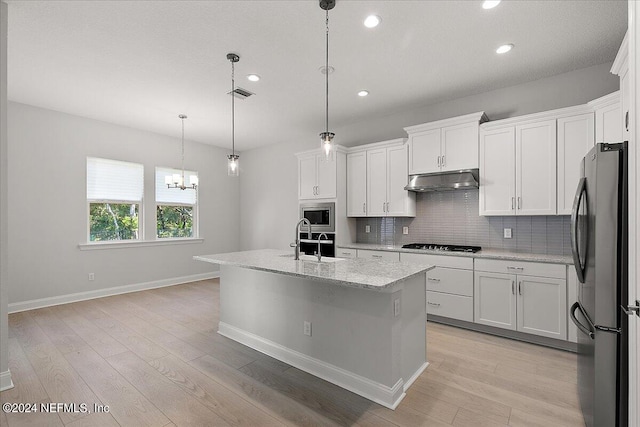 kitchen featuring pendant lighting, an island with sink, appliances with stainless steel finishes, and white cabinetry