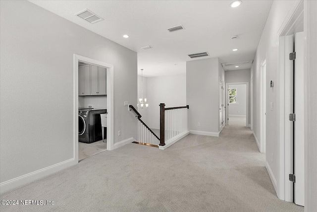 hallway featuring washer / dryer and light carpet