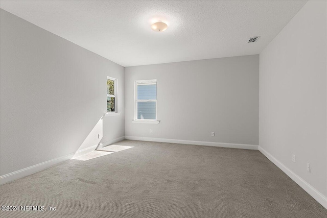 carpeted spare room featuring a textured ceiling