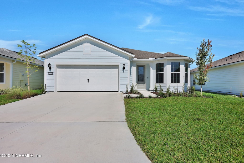 single story home featuring a front lawn and a garage