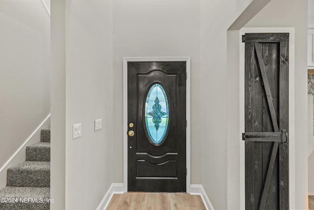 foyer with light wood-type flooring and a barn door