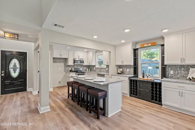 kitchen featuring appliances with stainless steel finishes, white cabinets, and plenty of natural light