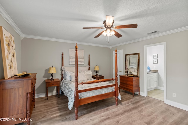 bedroom featuring a textured ceiling, ensuite bath, hardwood / wood-style flooring, and ceiling fan