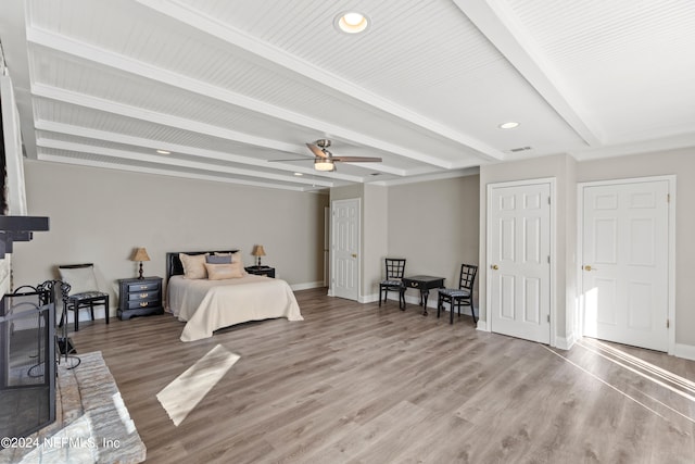 bedroom featuring ceiling fan, hardwood / wood-style flooring, and beam ceiling