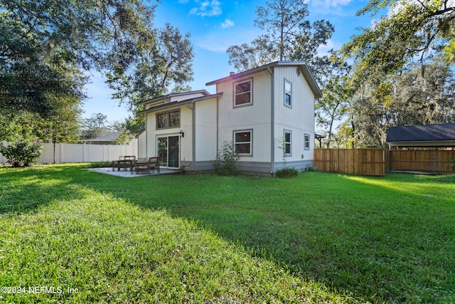 rear view of property featuring a patio area and a lawn