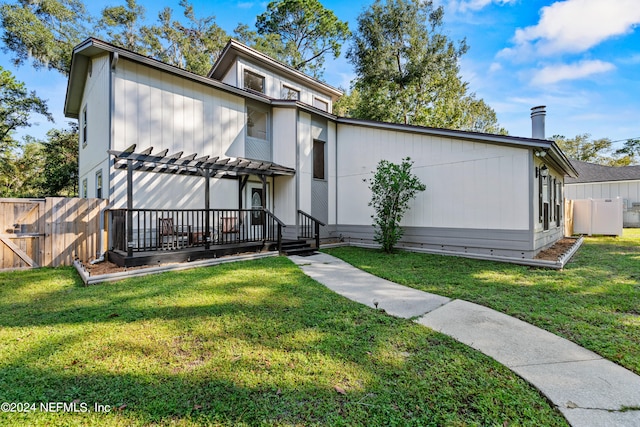 view of front of property with a pergola and a front yard