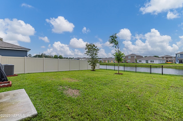 view of yard featuring a water view and central air condition unit