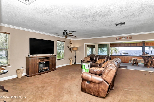 living room featuring ceiling fan, ornamental molding, plenty of natural light, and carpet flooring