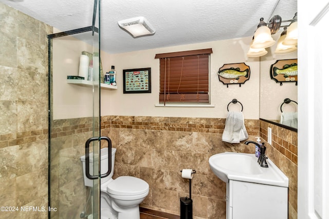 bathroom with walk in shower, vanity, tile walls, and toilet