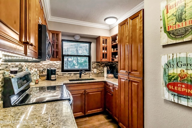 kitchen with light stone counters, appliances with stainless steel finishes, backsplash, and sink