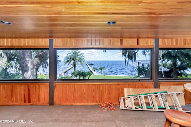 unfurnished sunroom with a water view and wooden ceiling