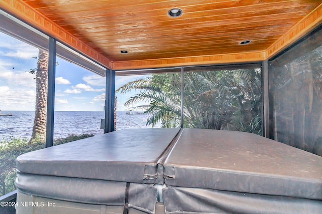 sunroom featuring plenty of natural light, a water view, and wooden ceiling