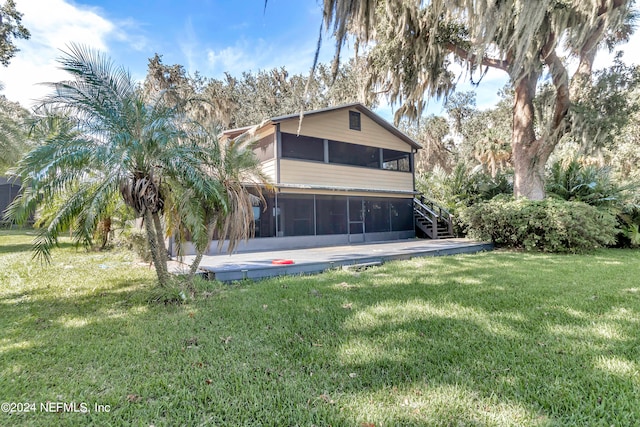 rear view of house with a yard and a sunroom