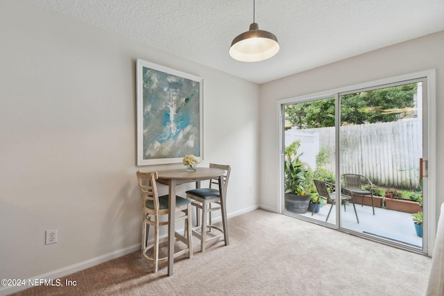 dining room featuring a textured ceiling and carpet flooring